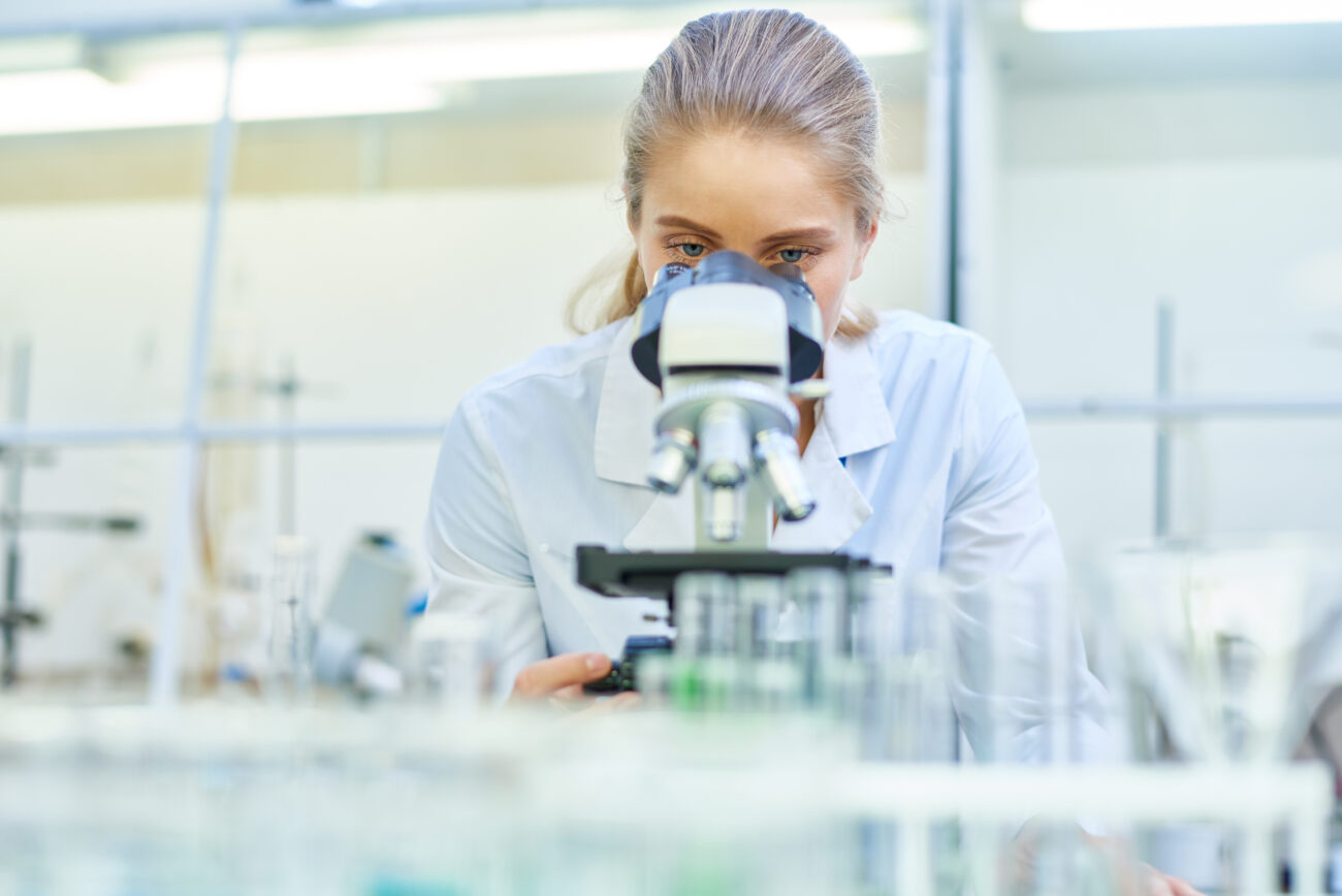 female scientist using microscope in laboratory