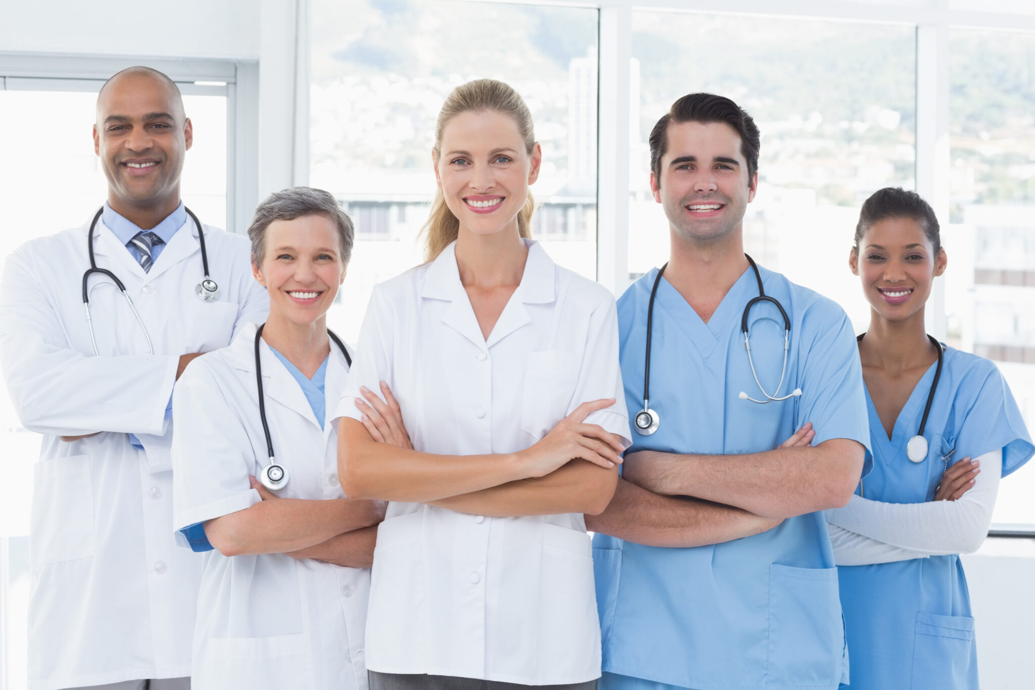 team of smiling doctors looking at camera in medical office