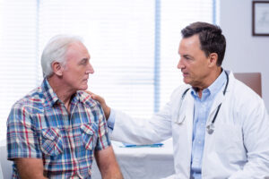 doctor consoling senior man